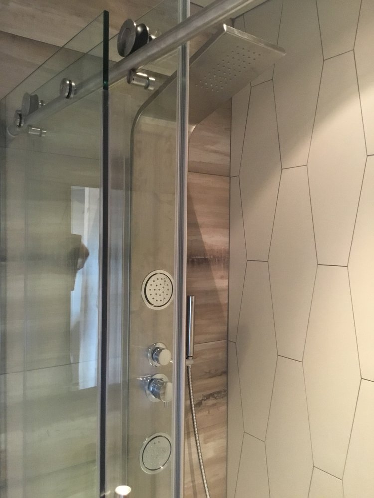 Macro detail of frameless glide shower hardware and rain panel installation