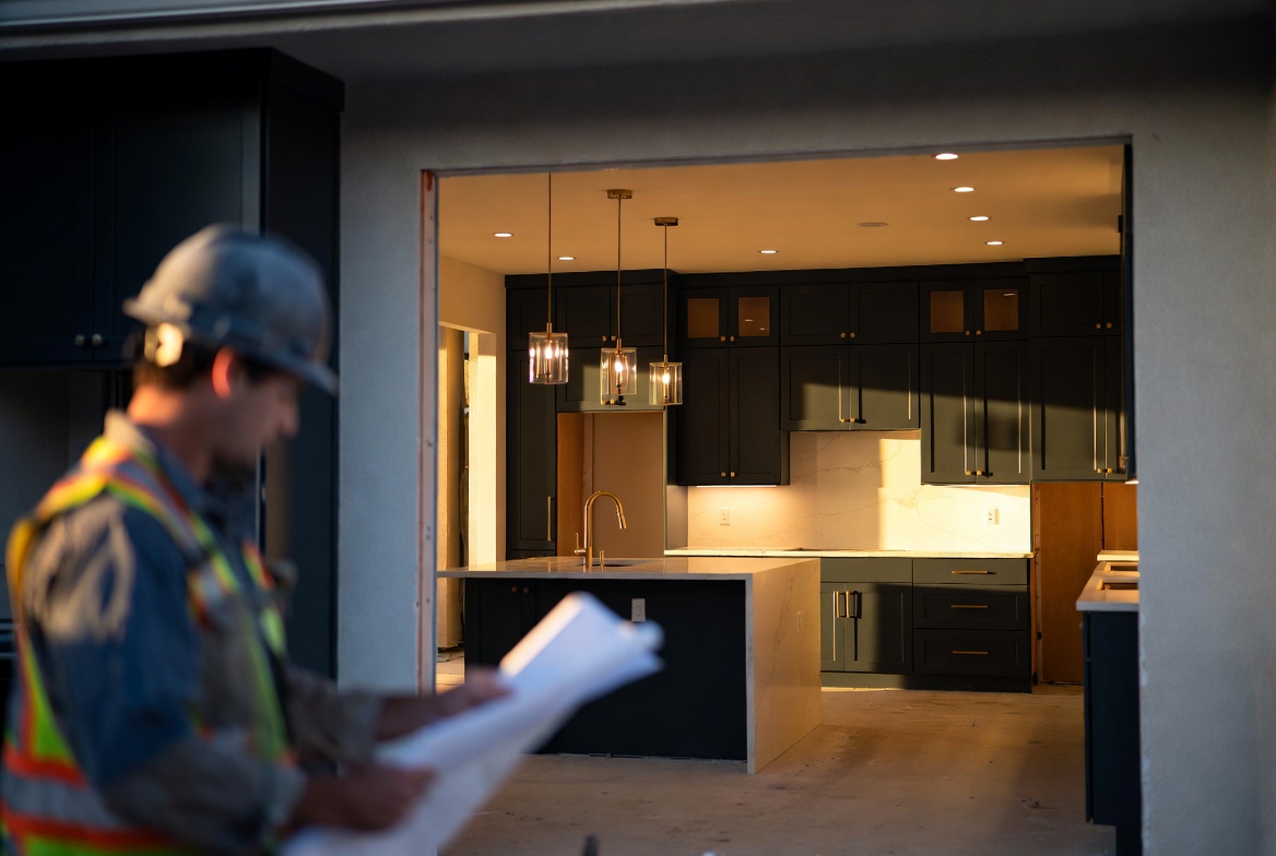 Pagac & Co general contractor reviewing blueprints in front of a newly remodeled kitchen with charcoal cabinetry in Concord, CA